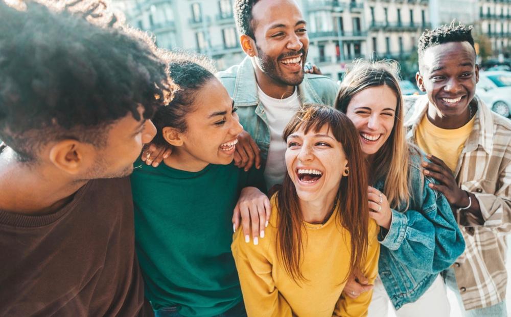 Un groupe d'étudiants divers et souriants, complices, dans la rue